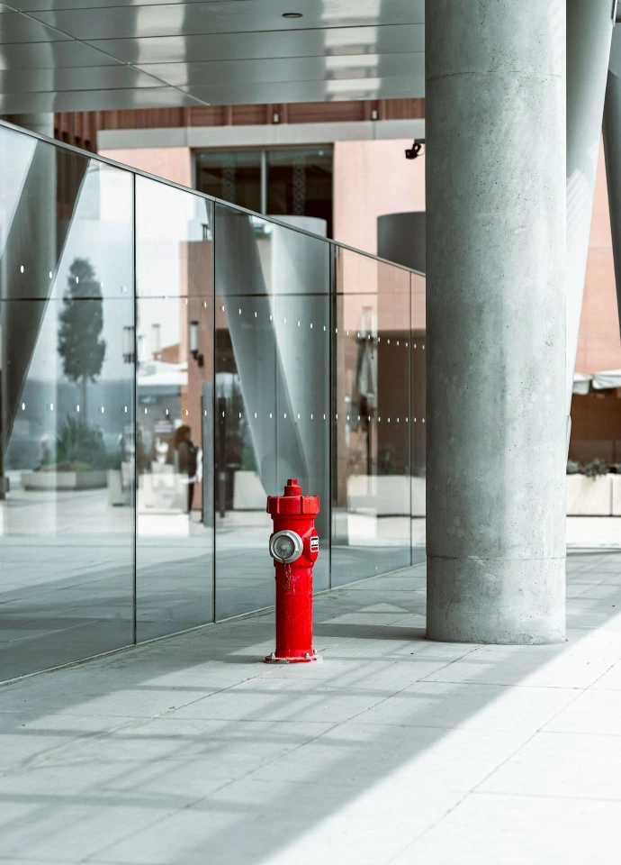 A bright red fire hydrant in a modern setting.